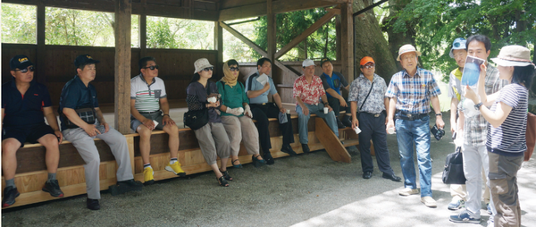 참가자들이 마을 탐방의 종착점인 긴린코 호수 앞에서 전설을 열심히 듣고 있다.